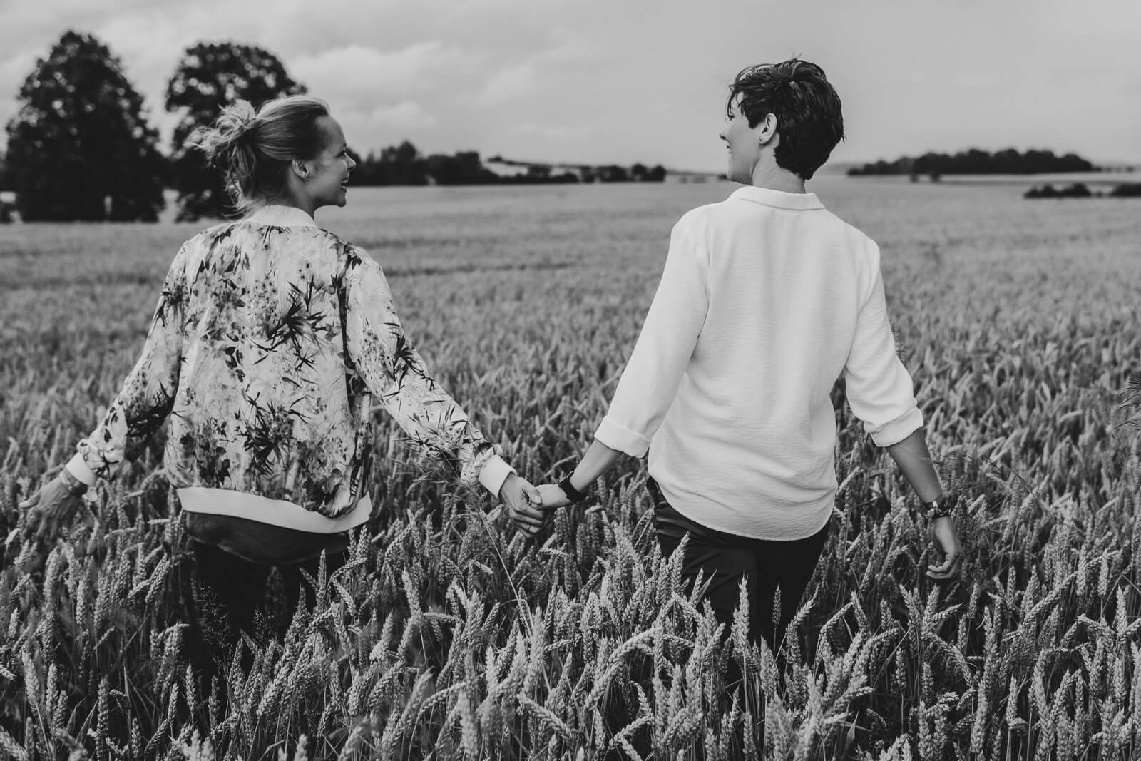 Familienfotograf-Leipzig-Pärchen-von-hinten-auf-Feld-schwarzweiß