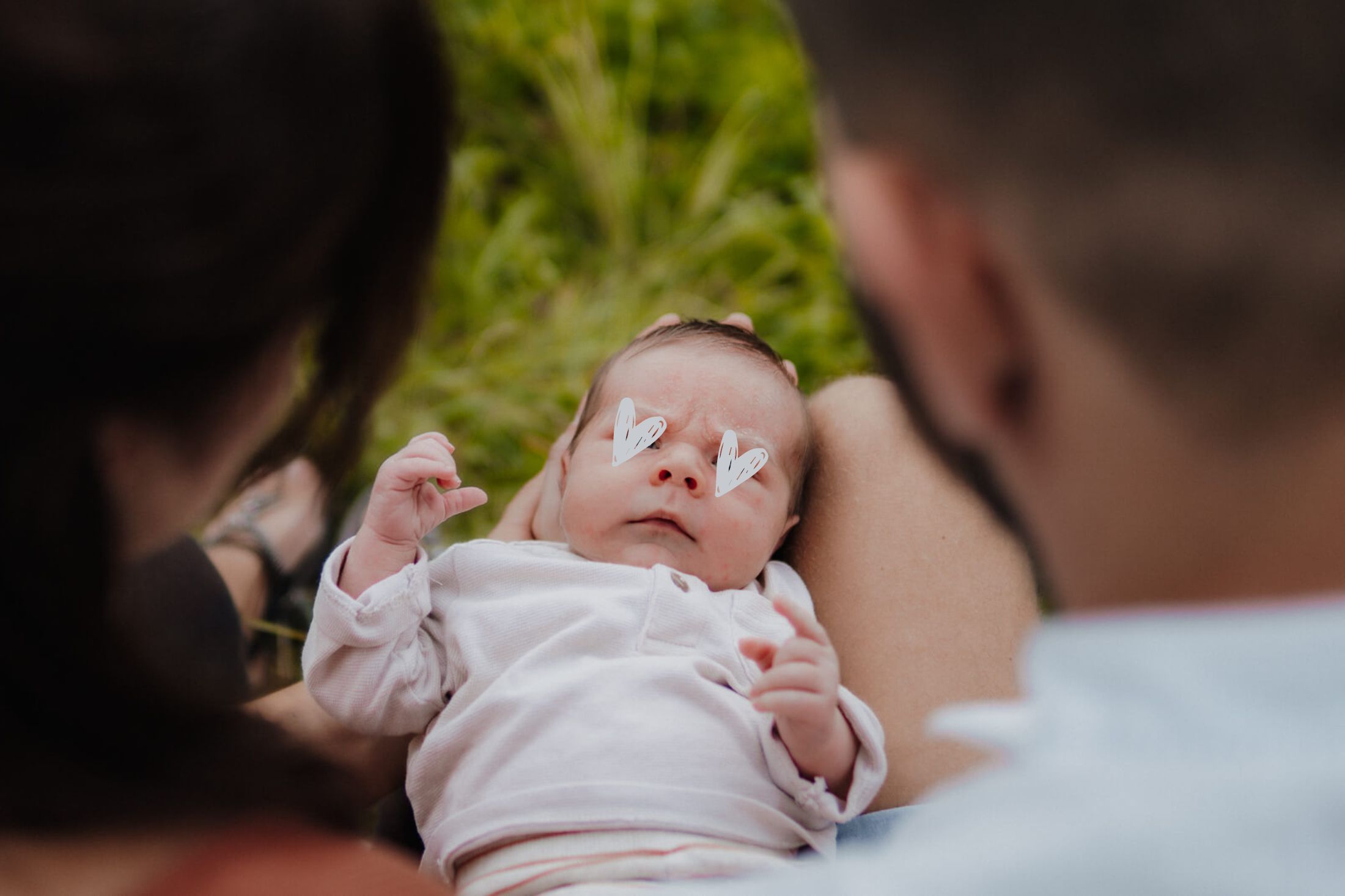 Zwischen den Köpfen der Eltern liegt das Baby